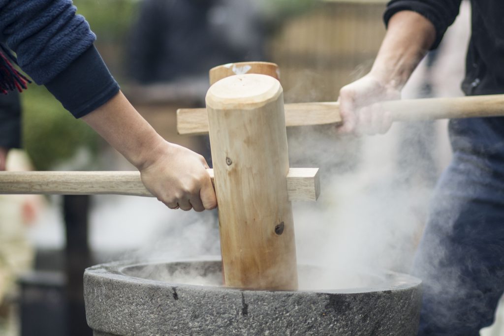 臼と杵を使って餅つきをする様子